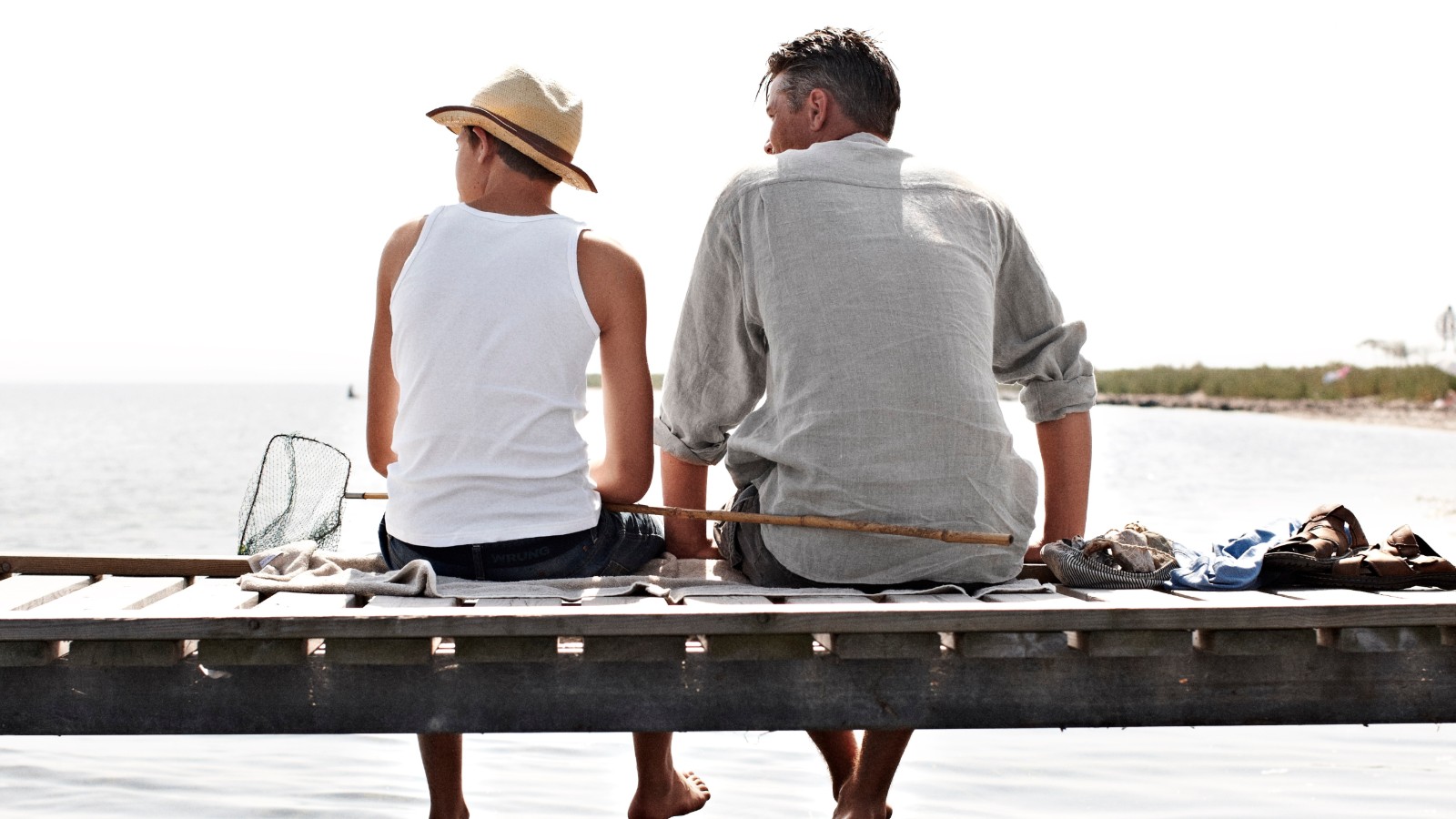Fejø, far og søn sidder på badebro