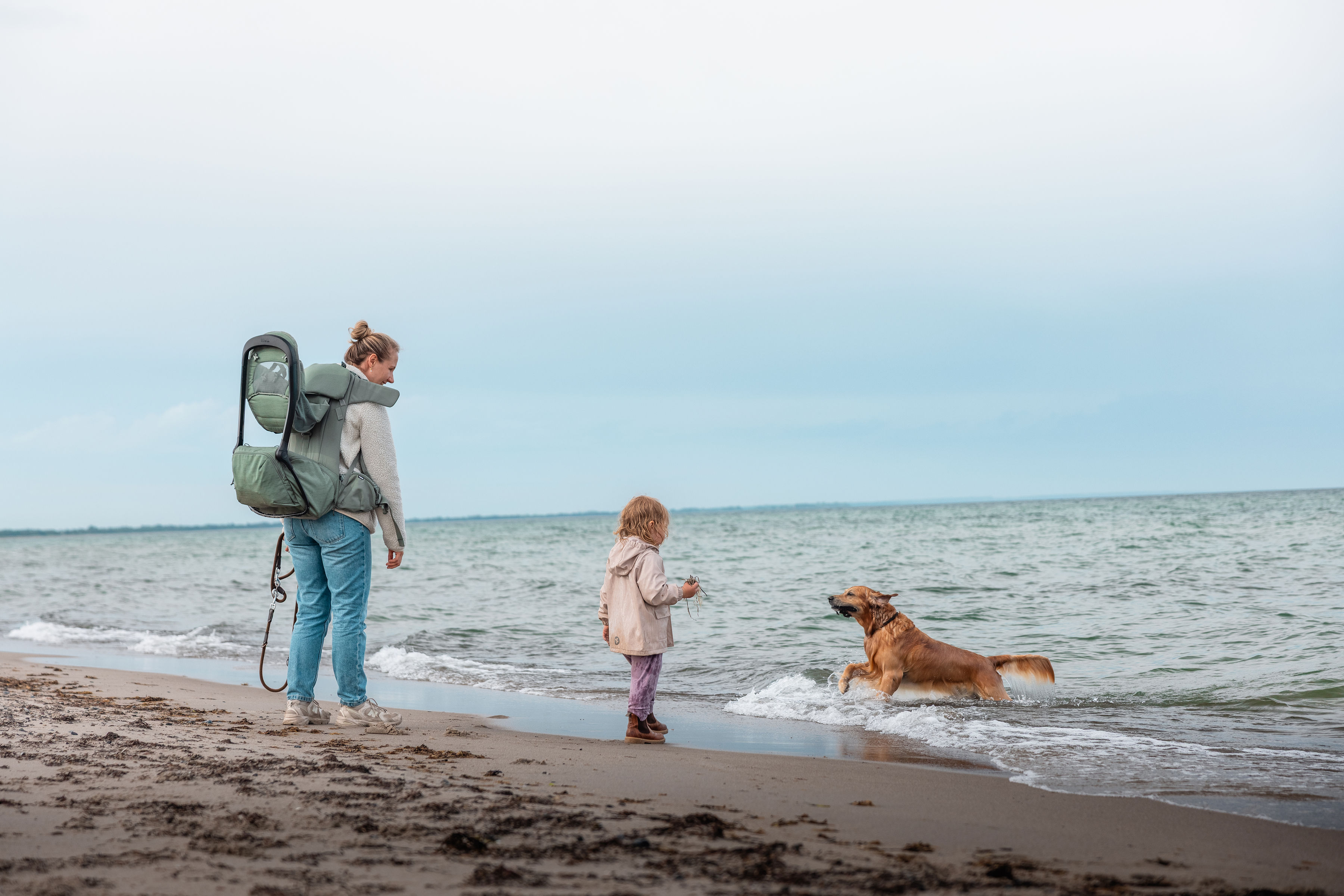 Kvinde, pige og hund går tur på Marielyst Strand