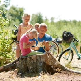 Familie i naturen med cykel